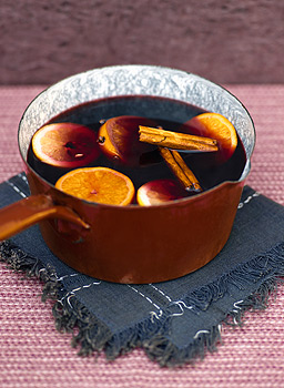 Mulled wine with orange and cinnamon in pot.